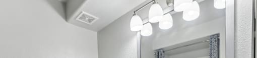 A bathroom with a toilet, sink, and mirror.