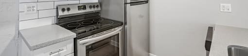 A kitchen with a stove, oven, microwave, and refrigerator.