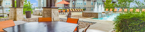 a patio with a table and chairs and a fountain