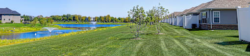 a yard with a house next to a body of water