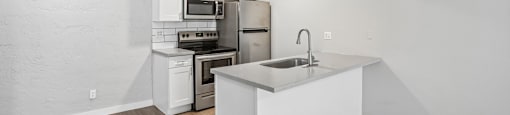 A kitchen with white cabinets and a white island.