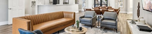 A living room with a brown couch, blue chairs, and a wooden coffee table.