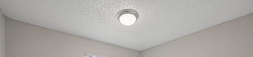A room with a window and a ceiling light.
