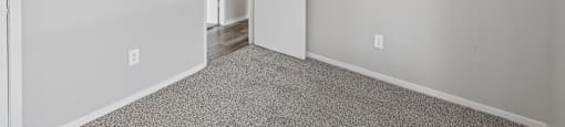 A room with a carpeted floor and a white door.