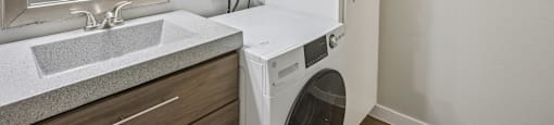 A white washing machine is in a small laundry room.