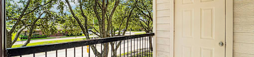 A white door is on the right side of a balcony.