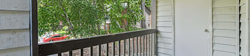 A balcony with a white door and a black railing.