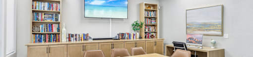 A conference room with a large table, chairs, and a screen displaying a beach scene.
