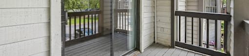 A balcony with a sliding glass door and a railing.