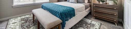 One Bedroom Senior Apartments in Boerne, TX | Boerne LIVIN | An Interior Shot of the Bedroom, Featuring Plush Carpeting, Large Windows, and High Ceilings
