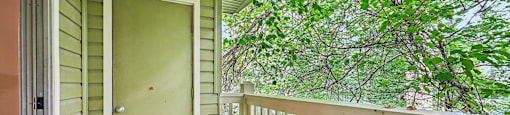 A green door is on the left of a porch.