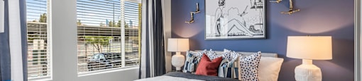 A bedroom with a large bed and a picture on the wall.