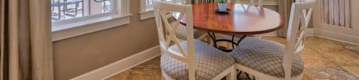 Pet-Friendly Apartments in Hinesville, GA – Tattersall Village - clubhouse seating area with table and chairs and view of the pool