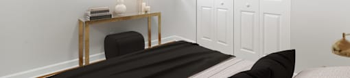 a bedroom with a bed and a desk with a lamp