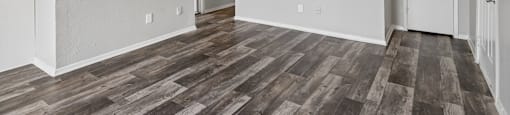 A room with wooden flooring and white walls.