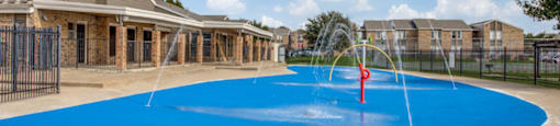 Outdoor splash pads with water features at Monarch Pass in Fort Worth, Texas, near South Fort Worth.