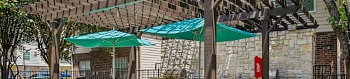 A patio with a table and chairs under a pergola.