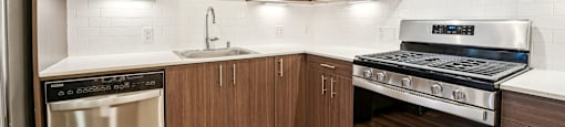 A modern kitchen with wooden cabinets and stainless steel appliances.