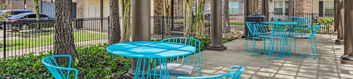 A patio with blue chairs and tables.