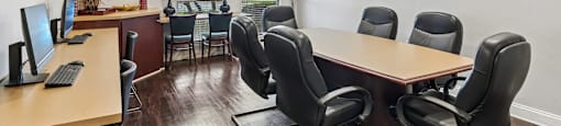 A conference room with a long table and chairs.