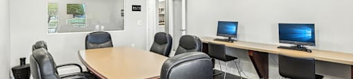 A conference room with a long table and chairs.