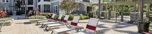 Poolside lounge chairs and resort-style amenities at The Lotus apartments in Starkey Ranch, Odessa, Florida