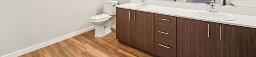 A bathroom with a toilet, sink, and mirror.