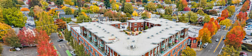 An aerial view of a street with a red brick building on the corner.