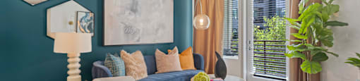 A living room with a blue wall and a white ceiling fan.