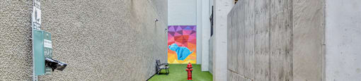 A narrow alley with a colorful mural on the wall.