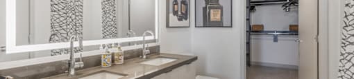 A bathroom with a toilet, sink, and mirror.