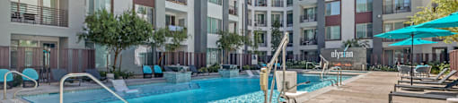 A swimming pool in front of apartment buildings.