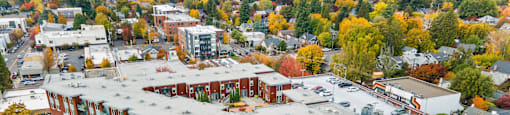 A large red brick building with a green roof in the middle of a street.