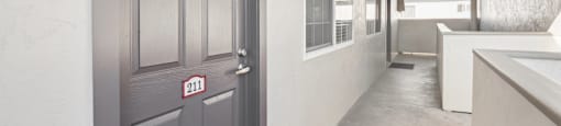 A grey door with the number 211 on it is closed.
