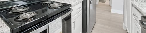 A kitchen with a black stove top oven and a black refrigerator.