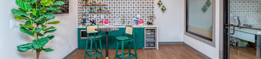 a dining room with a table and chairs and a kitchen with a plant
