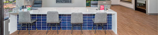 a conference room with a white counter and blue chairs
