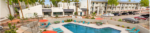 a view of a pool with chairs and an umbrella