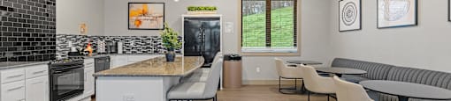 A modern kitchen with a large island and a dining area with grey couches.