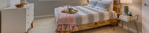One Bedroom Apartments in Tigard, OR - Sygnii - Bedroom with Wooden Bed Frame, Matching Bedside Tables, Ceiling Fan, and Large Window.