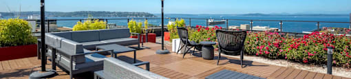 a deck with tables and chairs overlooking the ocean