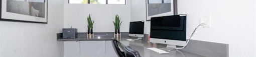 a desk with two computer monitors on top of it