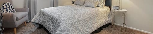 One-Bedroom Apartments in Mesa, AZ - Mesa Station - Cozy Bedroom with Carpeted Flooring, Wall Art, Queen Bed, and Large Window
