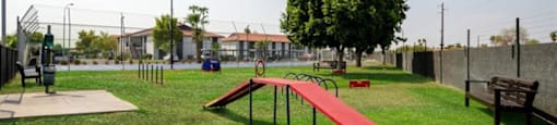 a park with a seesaw and benches on the grass