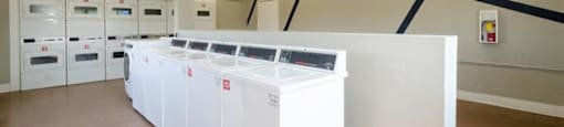 a row of washers and dryers in a room