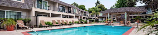 One-Bedroom Apartments in Fremont, CA - Brookvale Chateau - Pool with Outdoor Furniture, Potted Plants, and Umbrella Tables