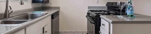 Fremont, CA Apartments Near Fremont Hub - Brookvale Chateau - Kitchen with Tile Floors, Granite-Style Countertops, and Stainless-Steel Appliances