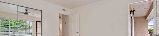 Two-Bedroom Apartments in Fremont, CA - Brookvale Chateau - Bedroom with a Ceiling Fan, Private Patio Access, and Mirror Sliding Closet Doors