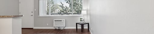 an empty living room with hardwood floors and a window