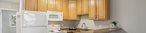 a kitchen with a granite counter top and white appliances